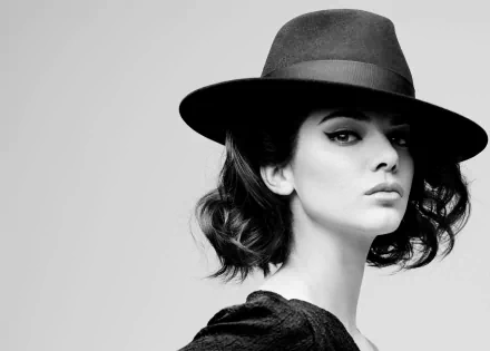 Black and white HD desktop wallpaper featuring a brunette woman in a stylish hat with bold eyeliner, tagged as Kendall Jenner.