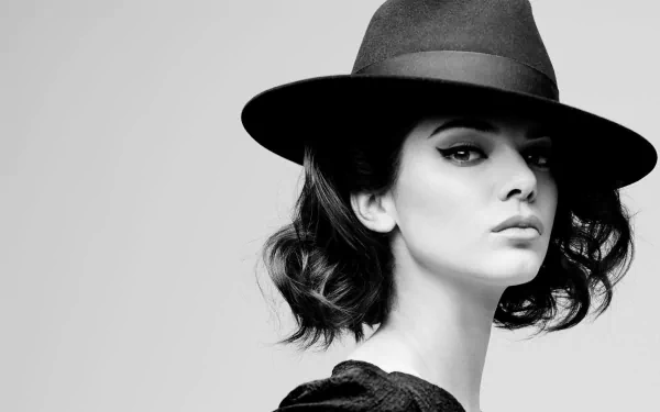 Black and white HD desktop wallpaper featuring a brunette woman in a stylish hat with bold eyeliner, tagged as Kendall Jenner.