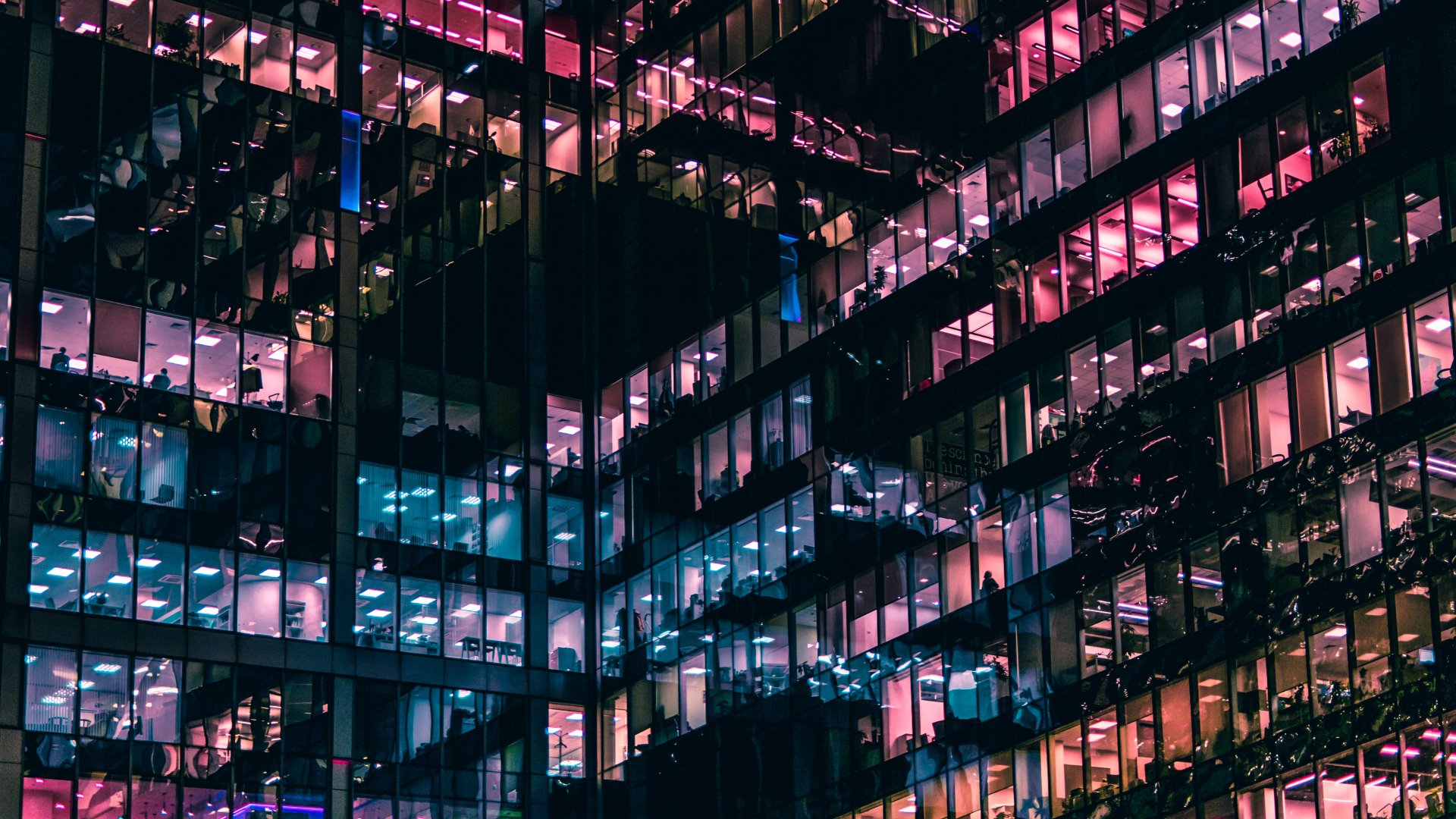 4K Ultra HD desktop wallpaper showcasing a detailed view of modern architecture with illuminated office windows in a high-rise building at night.