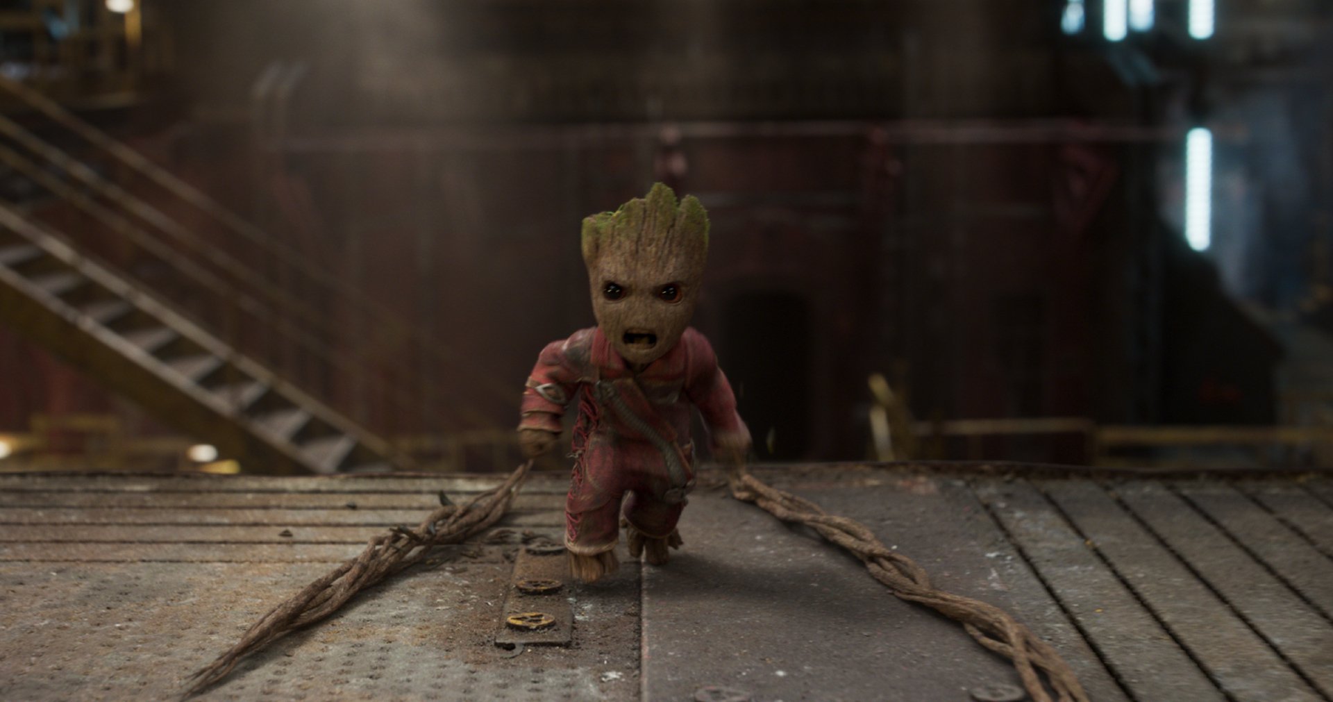 HD wallpaper featuring Baby Groot from the movie Guardians of the Galaxy Vol. 2. The character is in an industrial setting, emphasizing his determined expression.