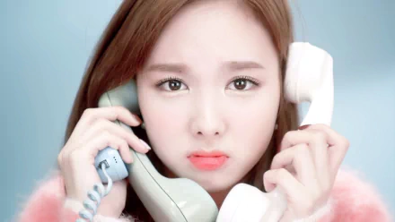 HD desktop wallpaper and background featuring a member of the music group TWICE, holding two phones with a concerned expression.