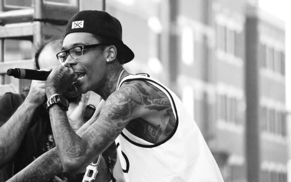Wiz Khalifa performs passionately on stage, captured in a dynamic black and white shot. This HD wallpaper brings music to life in any desktop background.