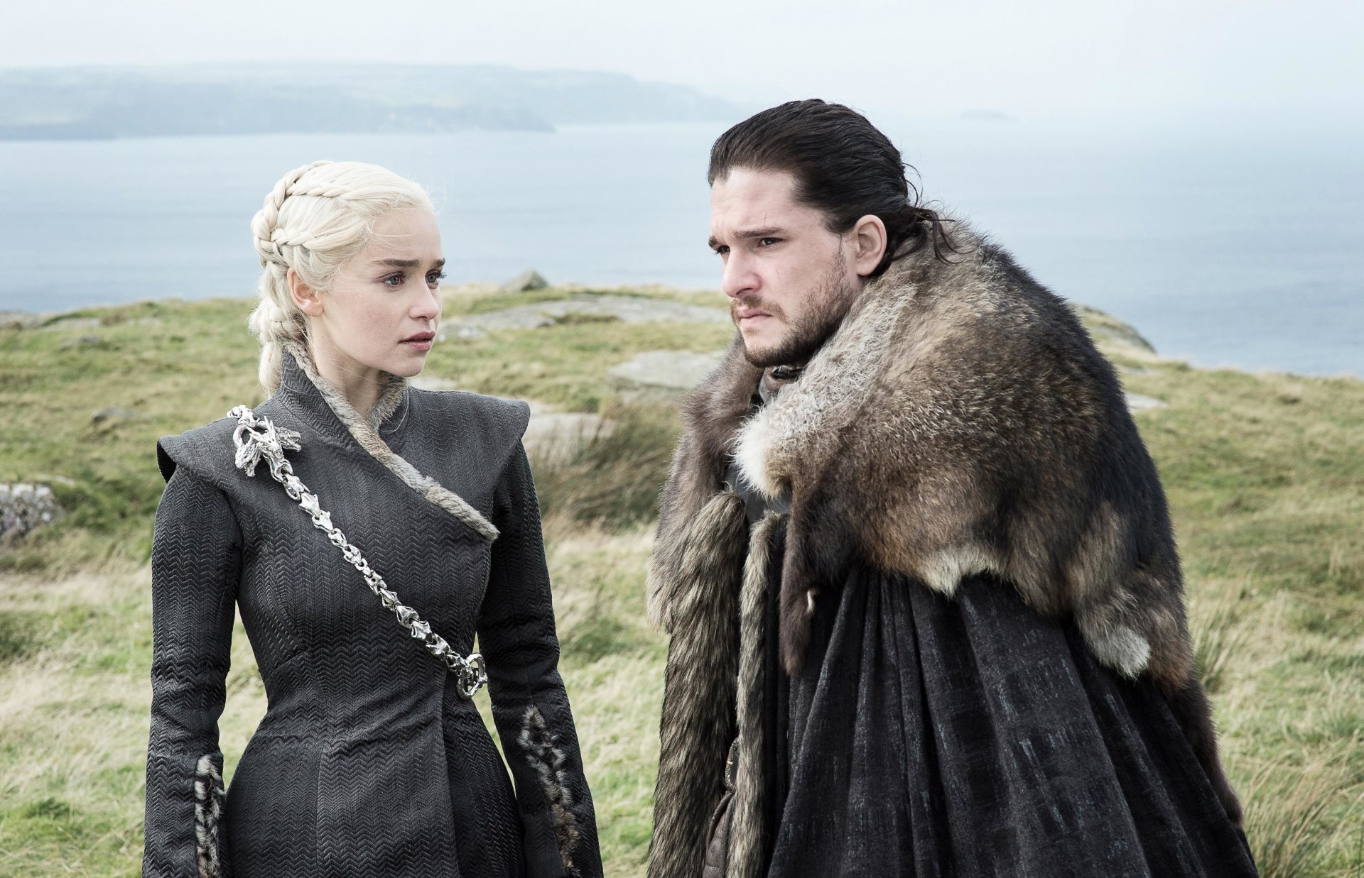 HD desktop wallpaper featuring Kit Harington as Jon Snow and Emilia Clarke as Daenerys Targaryen from the TV show Game of Thrones, set against a scenic, open landscape background.
