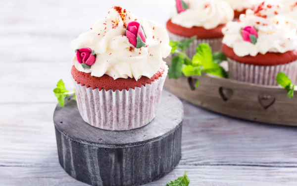 A close-up of a sweet cupcake with cream frosting and decorative pink roses, captured in vibrant 4K Ultra HD for a rich PC desktop wallpaper background.