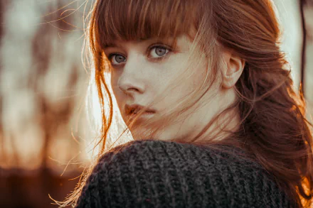 HD desktop wallpaper featuring a redhead woman with blue eyes, posing outdoors with a soft depth of field.