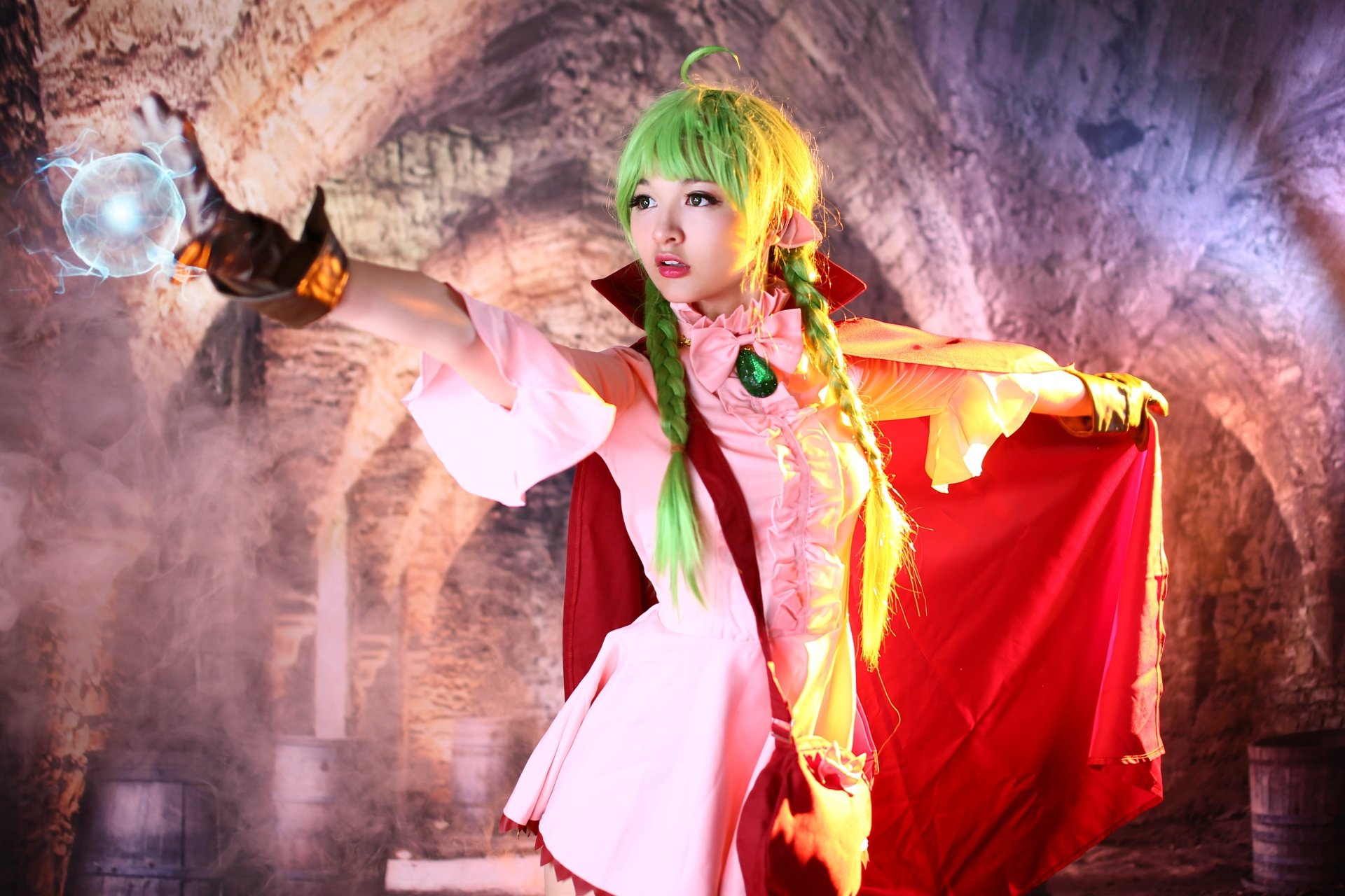 Asian woman with green eyes and braided green hair in cosplay, casting a glowing orb in a dramatic, stone-arched setting. 4K Ultra HD desktop wallpaper.