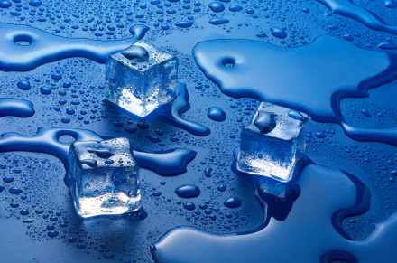 HD desktop wallpaper featuring three ice cubes on a blue surface with scattered water drops, showcasing vibrant blue tones and a refreshing, cool atmosphere.