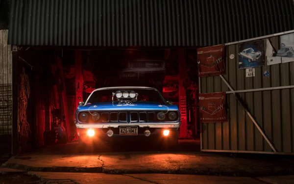 HD desktop wallpaper of a blue Plymouth Barracuda muscle car by Chrysler, illuminated in a dark garage with red lighting.
