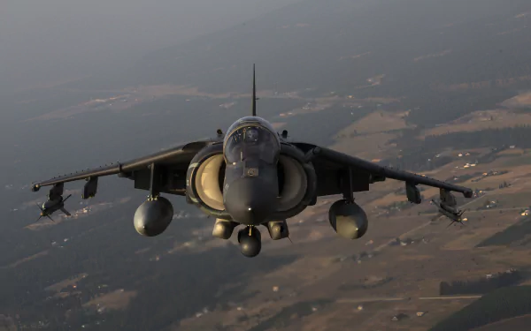 Front view of a McDonnell Douglas AV-8B Harrier II warplane jet fighter in flight over countryside — military aircraft 5K Ultra HD desktop wallpaper