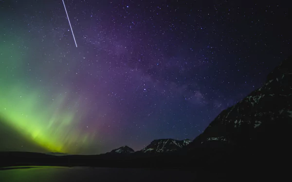 A 4K Ultra HD Sci Fi desktop wallpaper showing the Milky Way and northern lights over dark mountainous terrain at night.