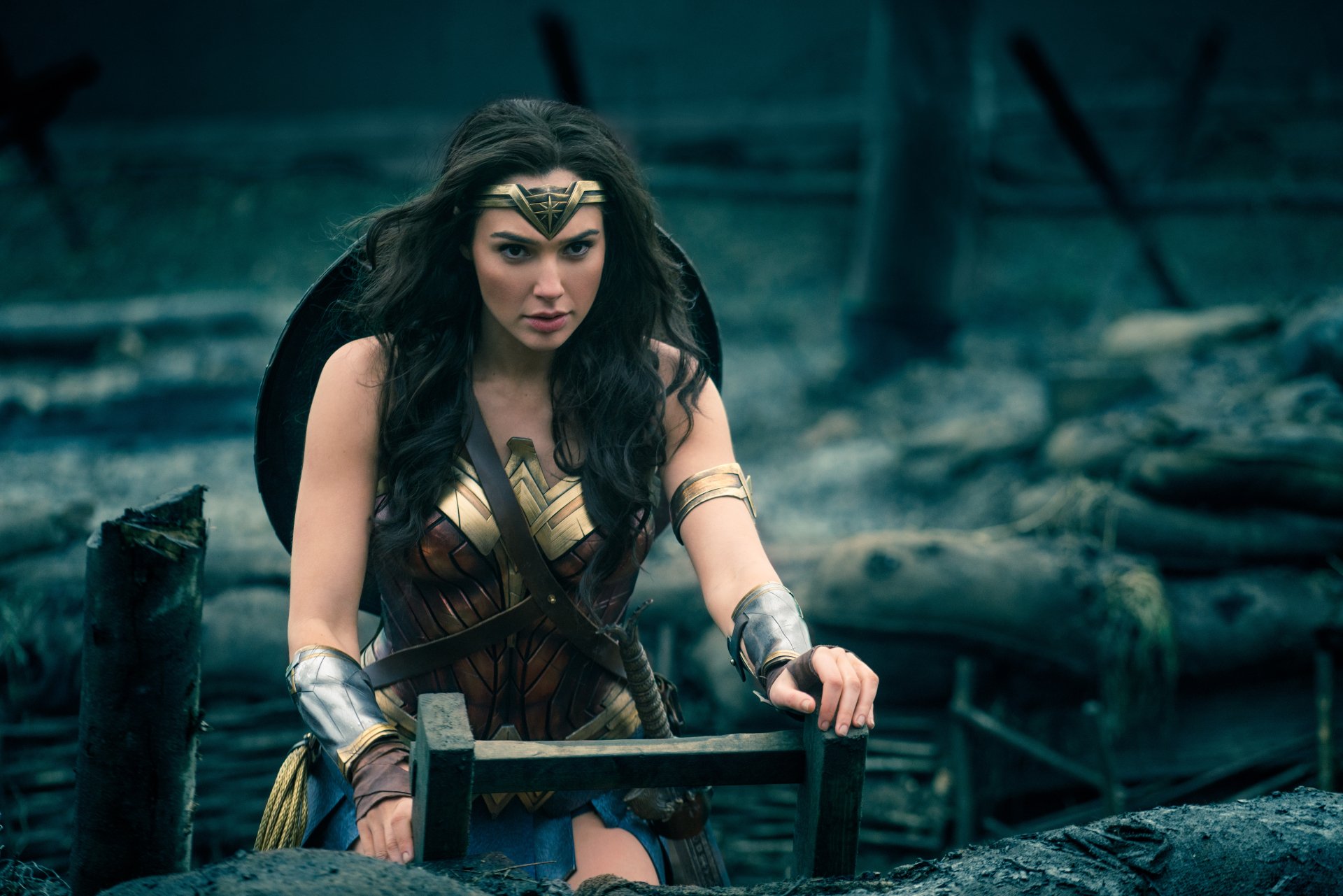 HD desktop wallpaper and background featuring Gal Gadot as Wonder Woman in a movie scene, showcasing her iconic warrior attire and determined expression amidst a battlefield setting.