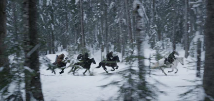 HD desktop wallpaper of Caesar from War for the Planet of the Apes, featuring a snowy forest scene with apes riding horses.
