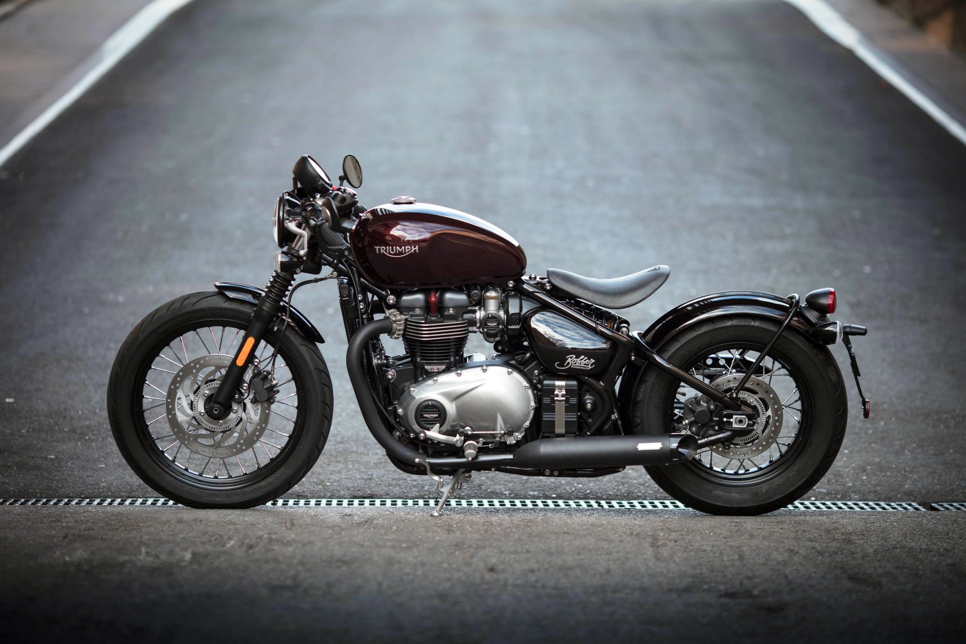 4K Ultra HD wallpaper of a Triumph Bonneville motorcycle, showcasing the sleek design and classic style on a smooth urban road.