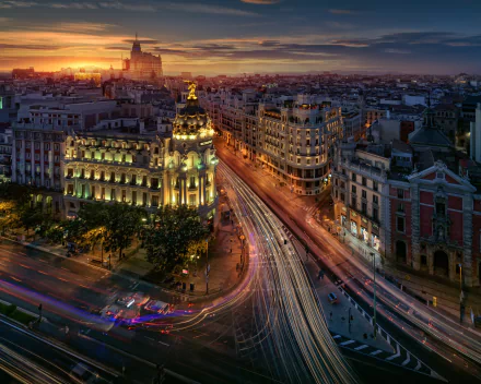 Time-lapse night cityscape of Madrid, Spain, showcasing illuminated historic buildings and busy streets in a vibrant HD desktop wallpaper background.