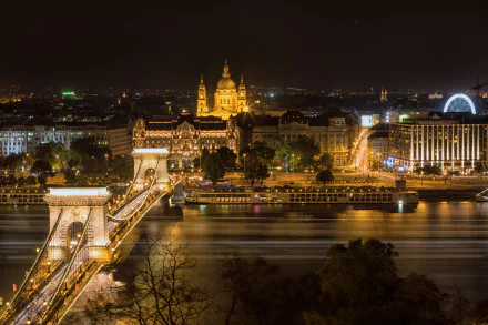 Night view of Budapest, Hungary, featuring the illuminated Chain Bridge over the river and historic buildings in the cityscape, captured in HD for a desktop wallpaper.