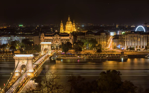 Night view of Budapest, Hungary, featuring the illuminated Chain Bridge over the river and historic buildings in the cityscape, captured in HD for a desktop wallpaper.