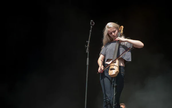 Clean Bandit member playing the violin on stage, in a high-definition image suitable as a desktop wallpaper or background.