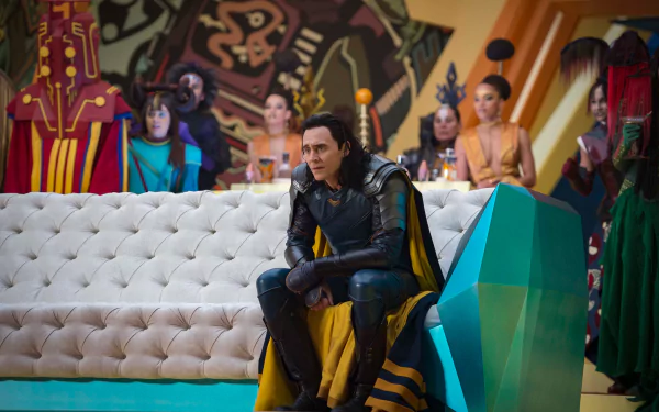 Loki (Tom Hiddleston) from Marvel's Thor: Ragnarok sits on a futuristic couch, surrounded by colorful characters, in this HD desktop wallpaper and background.