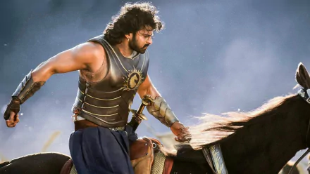 A scene from the movie Baahubali 2: The Conclusion, featuring the protagonist in armor riding a horse. This HD desktop wallpaper captures the epic and heroic essence of the film.