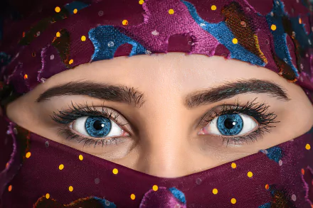 Close-up 4K Ultra HD PC desktop wallpaper of a woman's striking blue eyes framed by a colorful patterned headscarf, long lashes and defined brows.