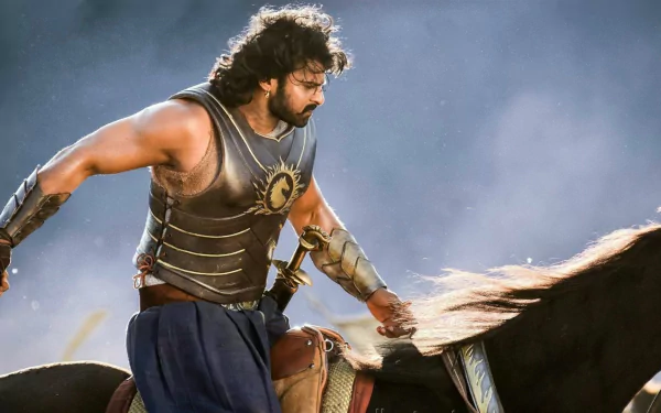 A scene from the movie Baahubali 2: The Conclusion, featuring the protagonist in armor riding a horse. This HD desktop wallpaper captures the epic and heroic essence of the film.