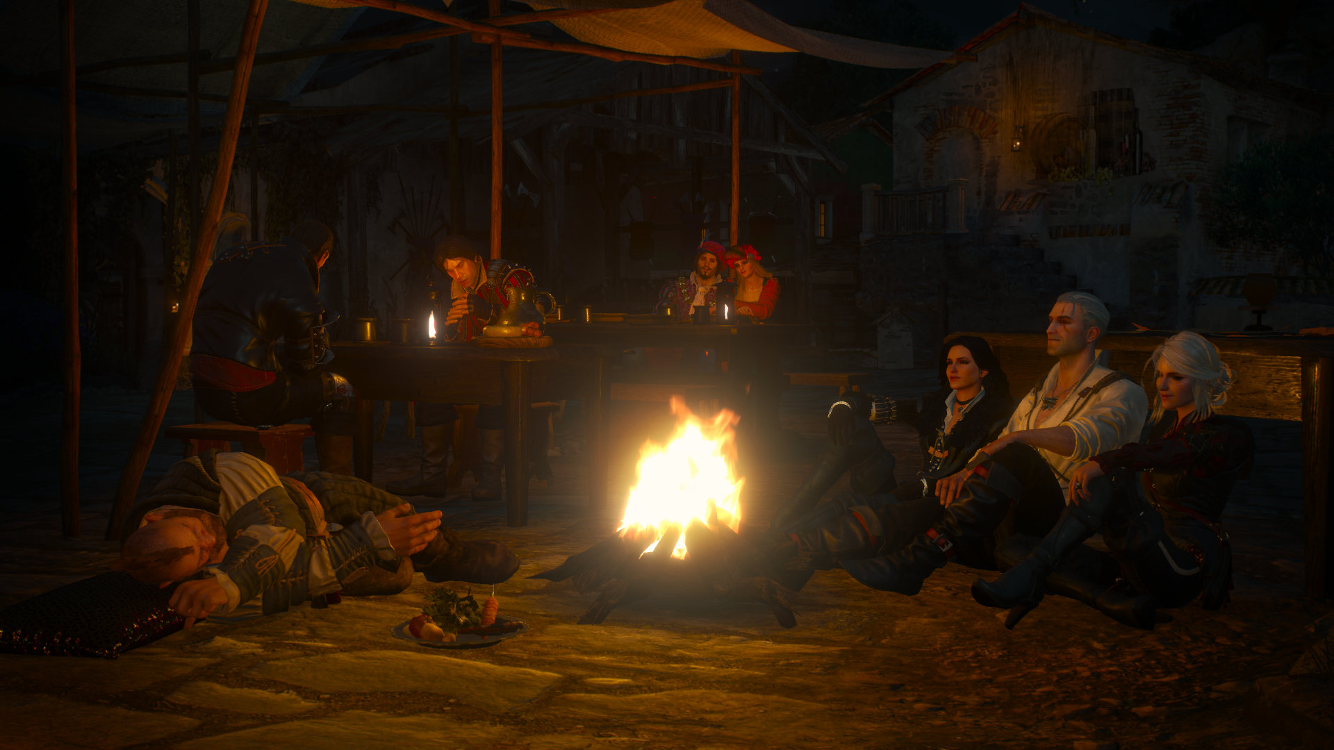 HD desktop wallpaper from The Witcher 3: Wild Hunt featuring Yennefer of Vengerberg, Ciri, and Geralt of Rivia sitting around a campfire at night in a cozy medieval setting.