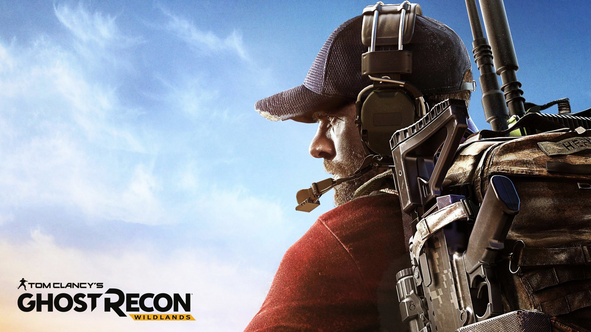 A HD desktop wallpaper featuring a character from the video game Tom Clancy’s Ghost Recon Wildlands, showcasing detailed gear against a clear blue sky backdrop.