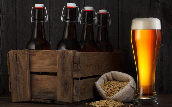 A 4K Ultra HD still life featuring a wooden crate with four dark glass beer bottles, a sack spilling malt grains, and a frothy glass of amber beer on a dark surface.