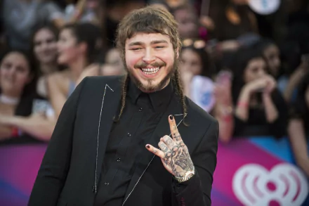 HD desktop wallpaper of Post Malone smiling in black attire with fans in the background.