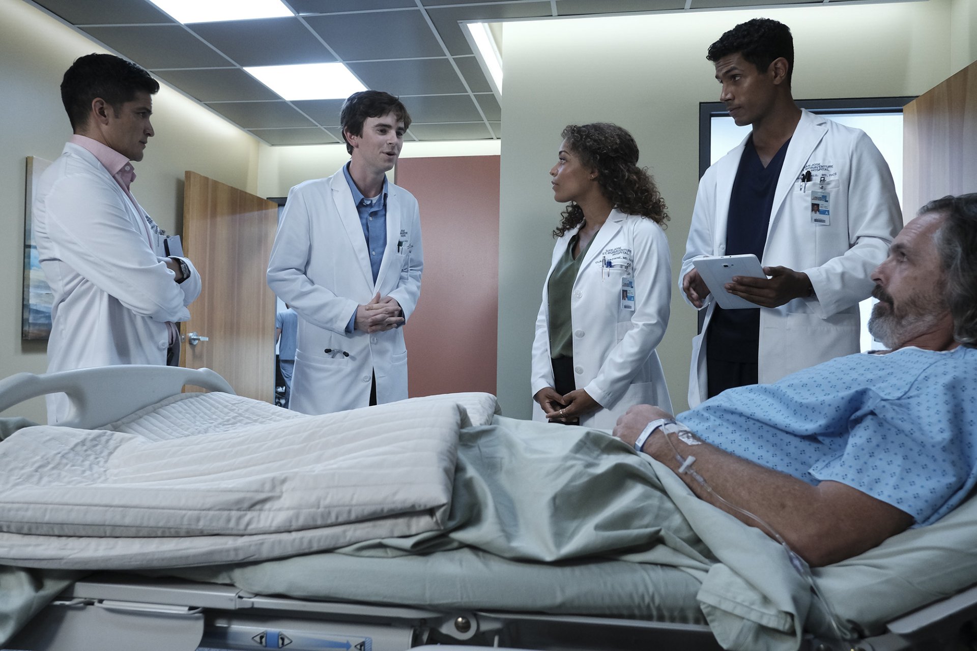 HD desktop wallpaper featuring characters from The Good Doctor in a hospital scene with a patient and doctors in conversation.