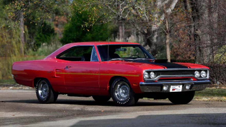 HD desktop wallpaper of a red Plymouth Hemi Cuda muscle car parked on a road with trees in the background.