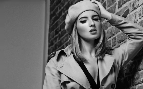 Black and white HD wallpaper featuring Spanish actress María Valverde wearing a beret and trench coat, posing against a brick wall.