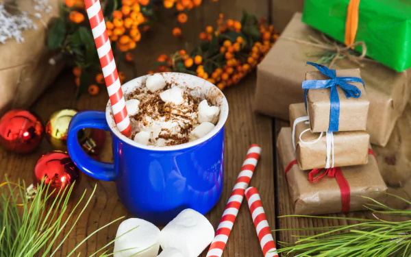 A vibrant still life 4K Ultra HD wallpaper featuring a blue cup of hot chocolate with marshmallows and candy canes, surrounded by wrapped gifts and festive decorations.