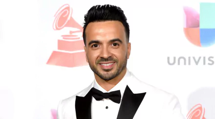 HD desktop wallpaper featuring a smiling man in a tuxedo with a bow tie at a red carpet event.