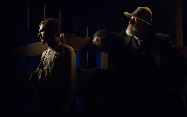 HD desktop wallpaper from Godless showing two characters in a moody, dimly-lit scene.