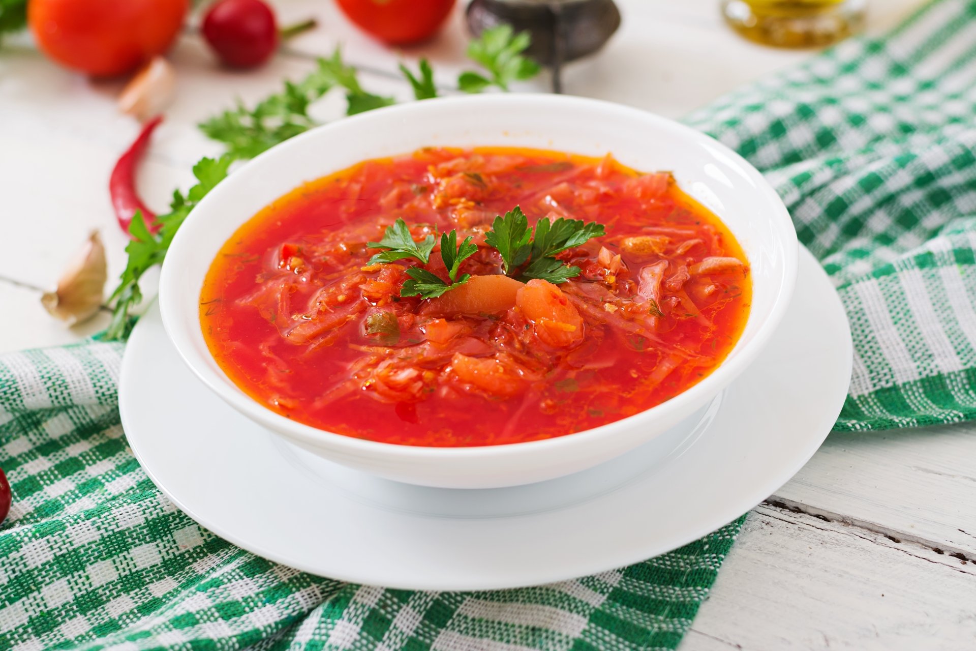 5K Ultra HD PC desktop wallpaper showing a bowl of vibrant red vegetable soup garnished with parsley on a white plate atop a green-checkered cloth.