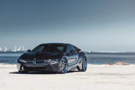 Sleek black BMW i8 supercar parked on a concrete surface by the water with a city skyline in the distance, captured in 4K Ultra HD for a stunning desktop wallpaper.
