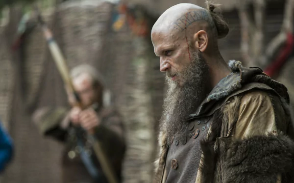 8K Ultra HD desktop wallpaper featuring a scene from the TV show Vikings (2013) with a focused warrior in detailed period attire and a blurred figure in the background.