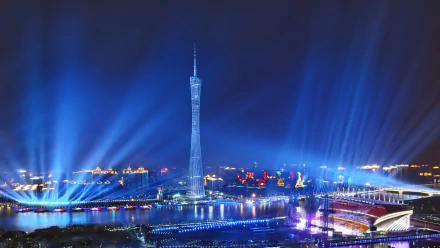 HD wallpaper featuring the illuminated Canton Tower at night in Guangzhou, China, with radiant blue lights beaming into the sky.