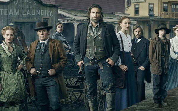 HD desktop wallpaper featuring the main cast of the TV show Hell on Wheels standing in a historic Western town setting.
