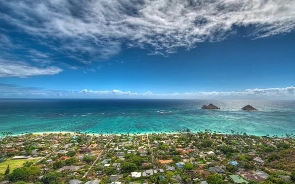 A vibrant HD desktop wallpaper featuring the ocean and horizon at Lanikai Beach, Oahu, with palm trees and a coastal town visible under a partly cloudy sky.