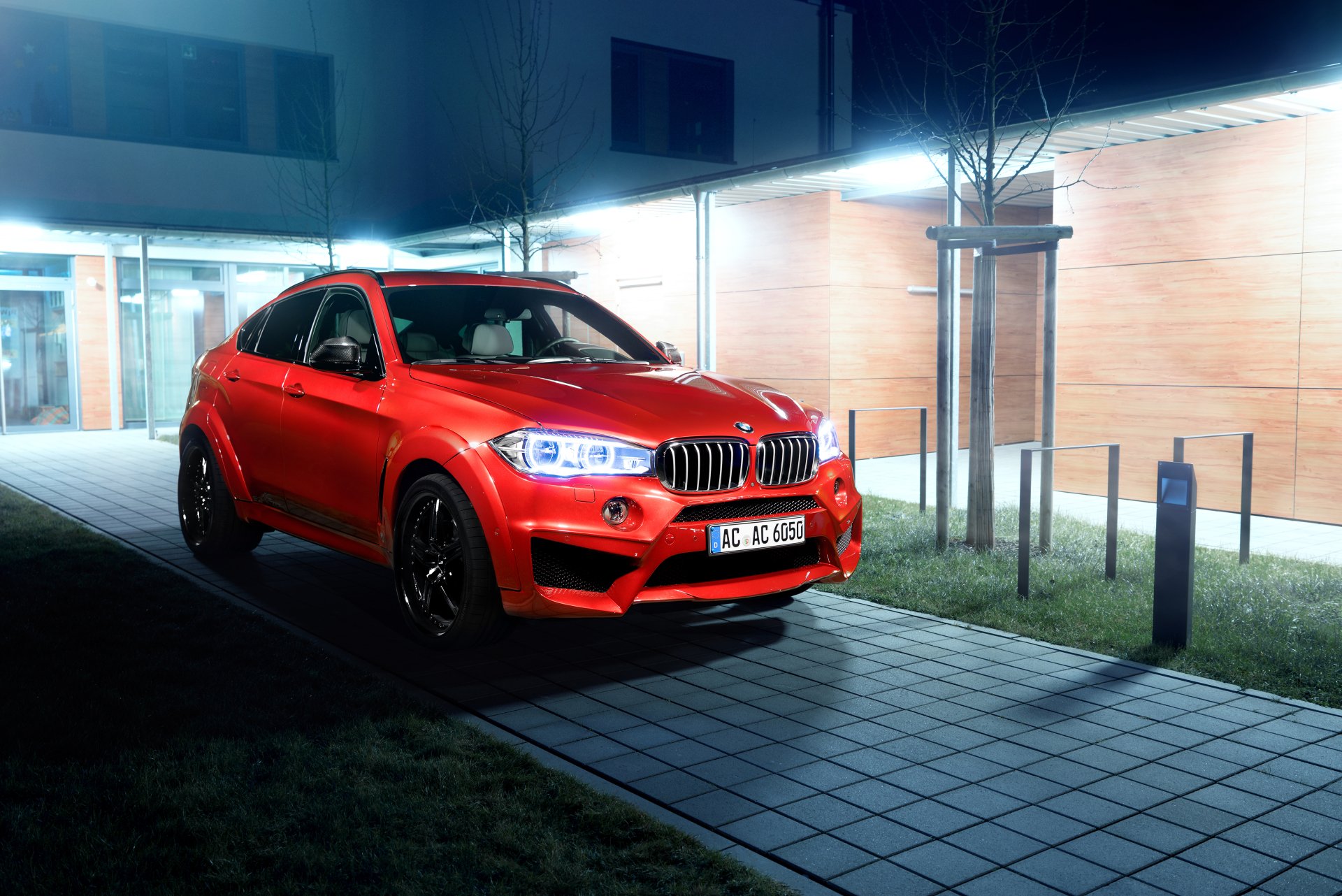 Red BMW X6 SUV parked at night by a modern building, high-contrast 4K Ultra HD PC desktop wallpaper showcasing a sporty BMW vehicle.