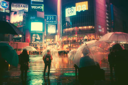 A nighttime city scene in Japan with glowing neon billboards and people holding umbrellas crossing a wet street, captured in HD for a vibrant desktop wallpaper.