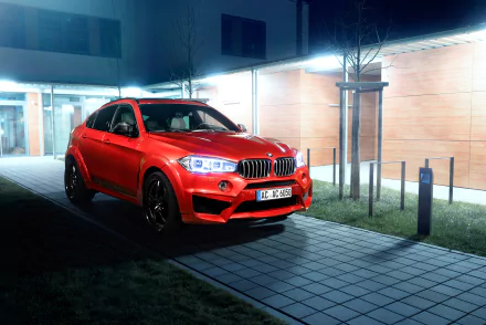 Red BMW X6 SUV parked at night by a modern building, high-contrast 4K Ultra HD PC desktop wallpaper showcasing a sporty BMW vehicle.