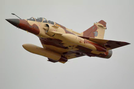 HD desktop wallpaper featuring a Dassault Mirage 2000 military jet fighter warplane in flight against a gray sky.
