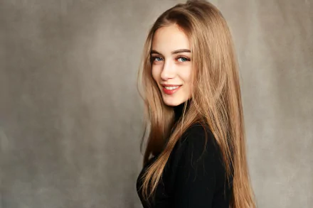 HD desktop wallpaper of a smiling blonde woman with long hair and blue eyes, posing confidently against a neutral background.