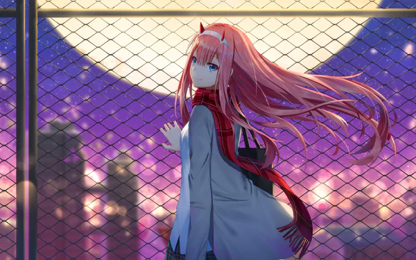HD desktop wallpaper featuring a character from the anime Darling in the FranXX with a vivid full moon and cityscape background. The character is standing by a chain-link fence, with flowing pink hair and a red scarf.