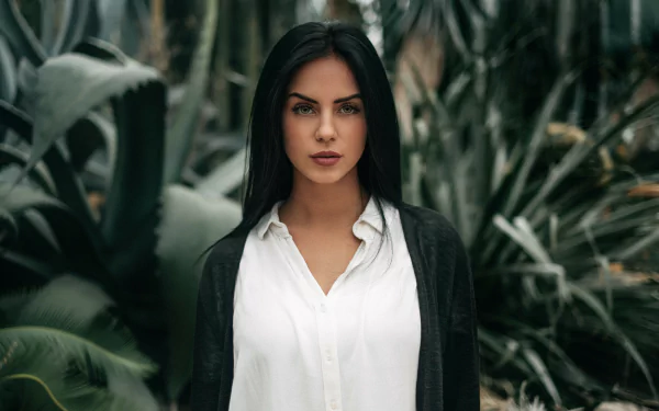 HD desktop wallpaper featuring a woman with black hair and lipstick, posing confidently amidst lush green foliage, credited to Marlen Valderrama Alvaréz.