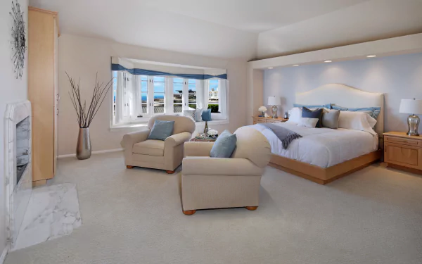 A modern, spacious bedroom featuring a large bed, cozy armchairs, and elegant furniture, captured in 4K Ultra HD for a crisp PC desktop wallpaper background.