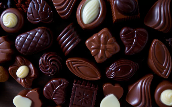 Close-up 4K Ultra HD PC wallpaper of assorted chocolates and sweets with rich textures and glossy finishes.